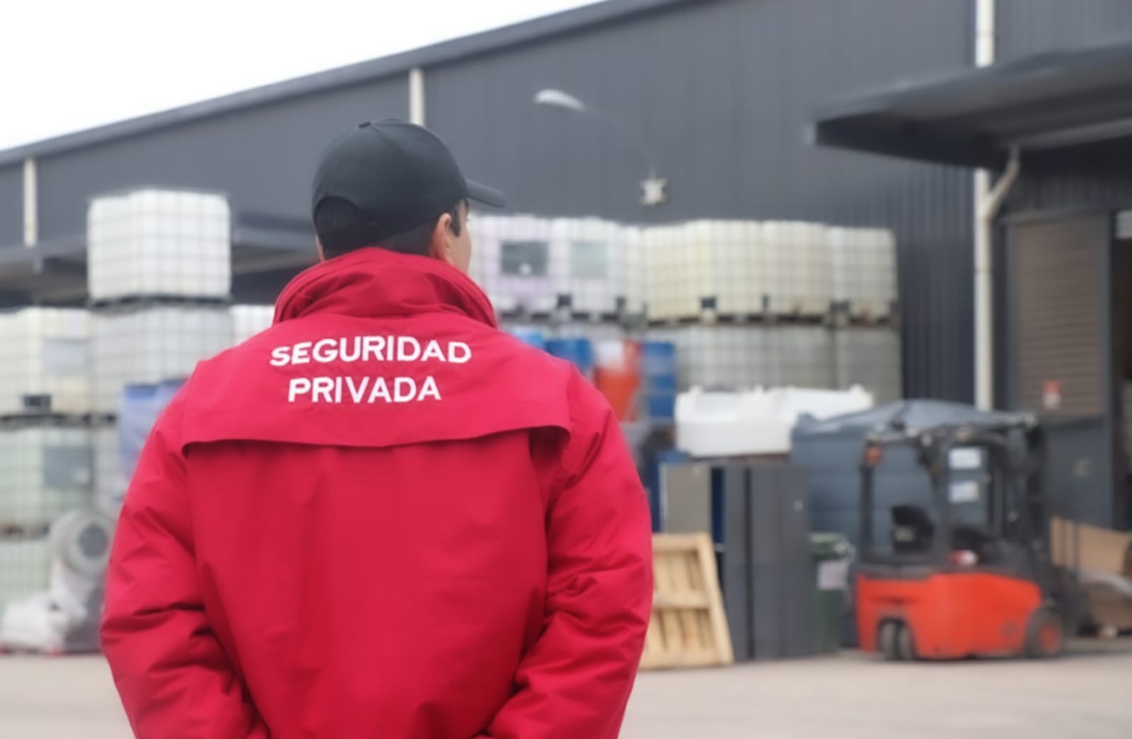 Guardia de seguridad privada vigilando un patio industrial